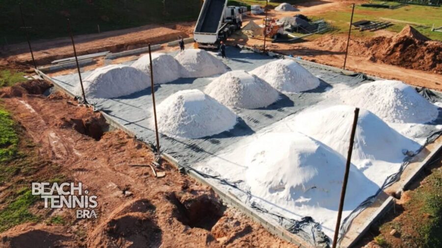 Colocação da manta e areia especial, garantindo drenagem e base firme para a quadra.